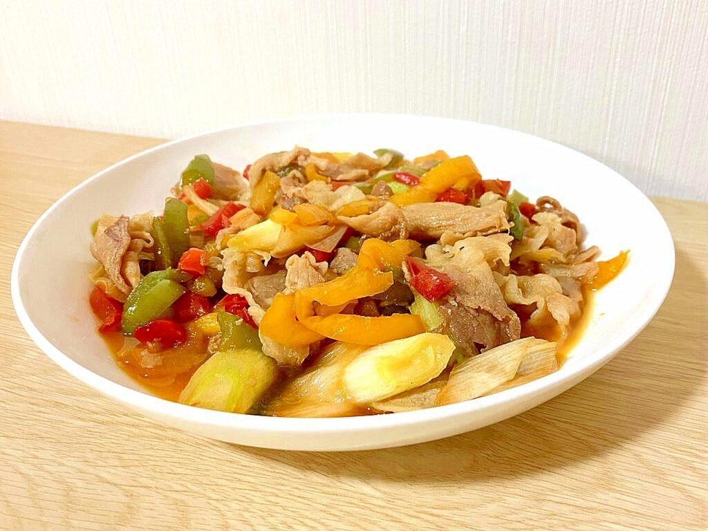 白い皿に入った長ねぎとパプリカの豚バラ肉野菜炒め