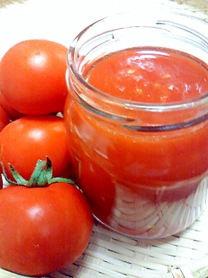 ガラス瓶に入っているトマトのジャムとその横のミニトマト