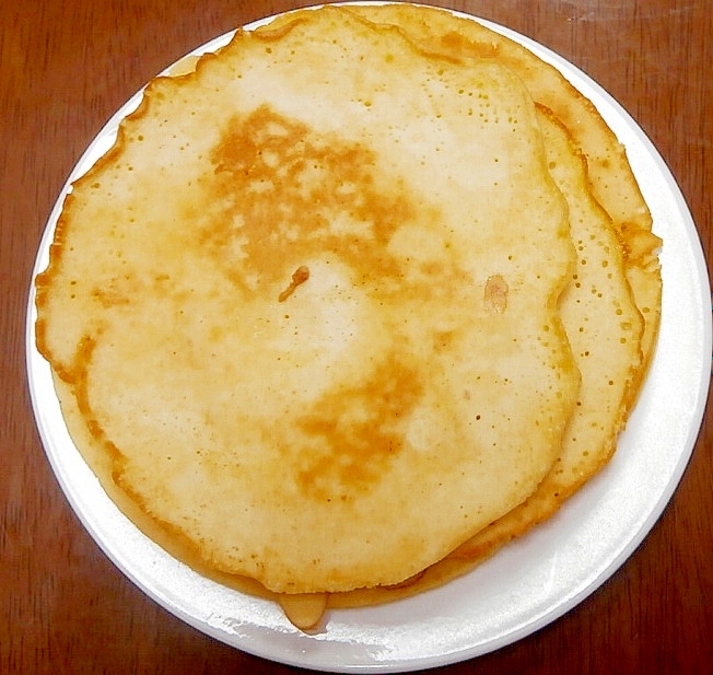白い皿に盛りつけられている3枚重ねの薄焼きおからパンケーキ