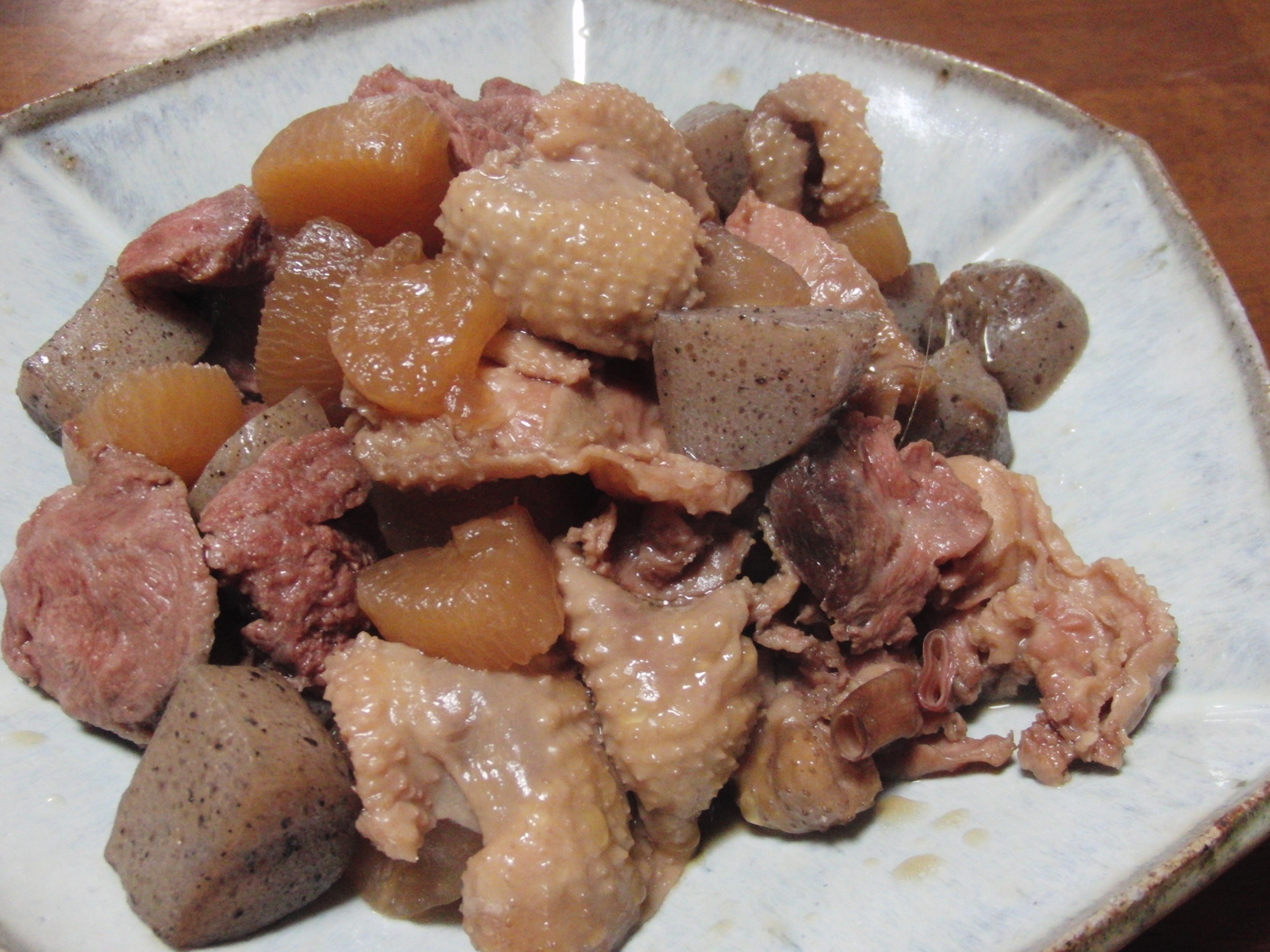 角皿に盛られたかしら肉、鶏皮、大根、こんにゃく、ごぼうの煮物