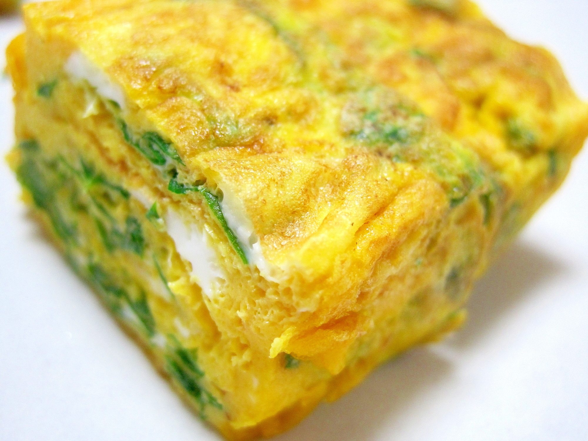 白色の皿に盛られたあしたばの卵焼き