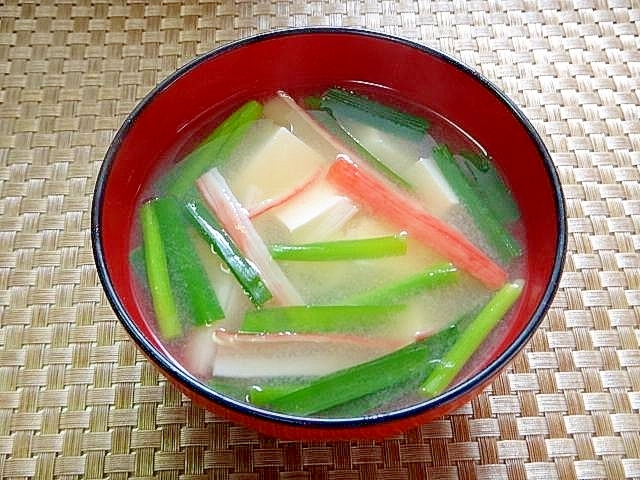 お椀に盛られたニラと豆腐とカニ風味かまぼこの味噌汁