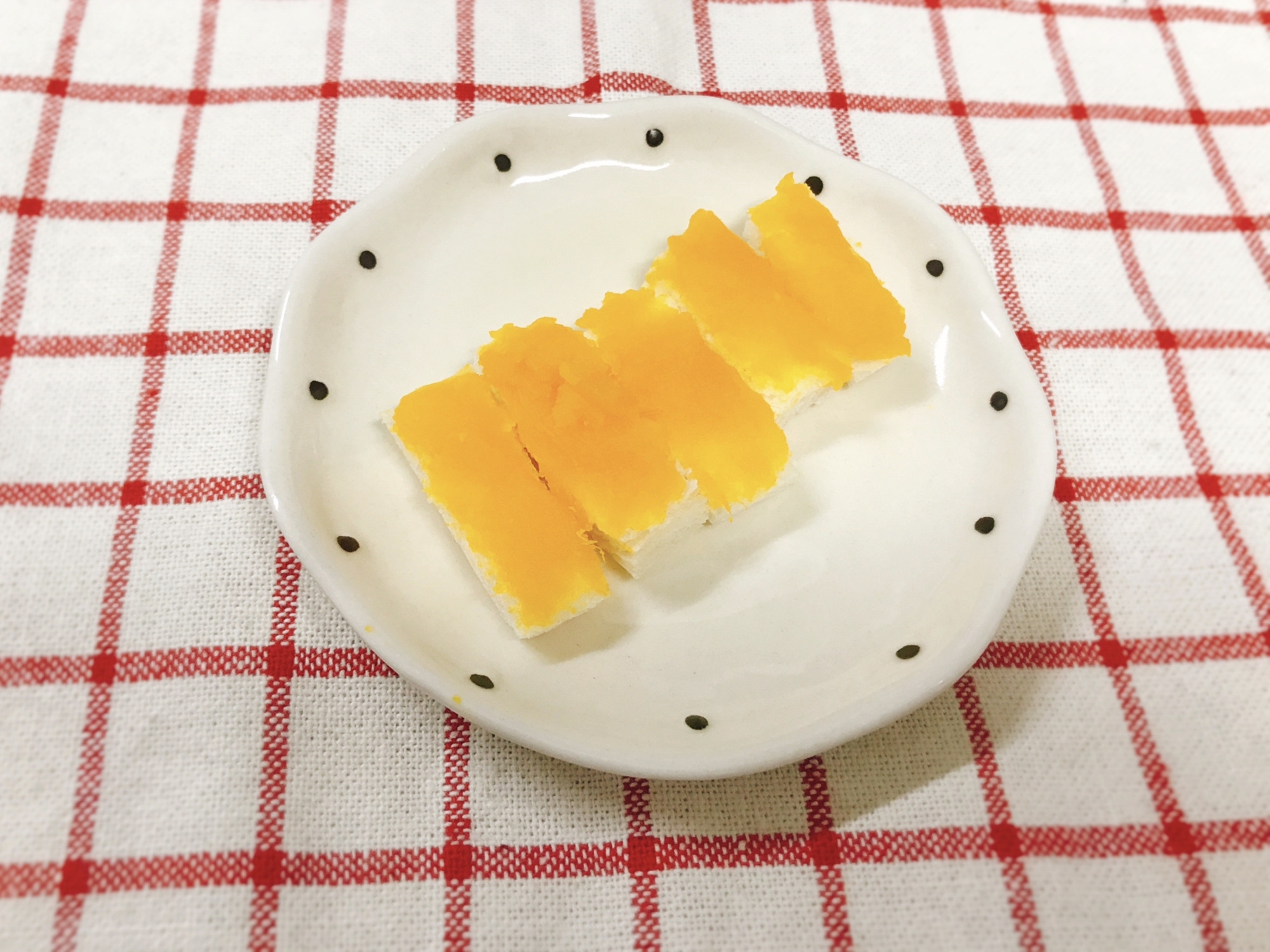 白い器にかぼちゃペーストが塗られた食パンが小さいスティック状に切って盛られている