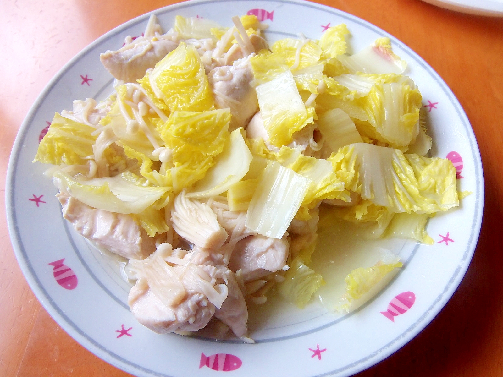 ピンク模様の皿に盛りつけられた鶏ささみと白菜、えのきの酒蒸し