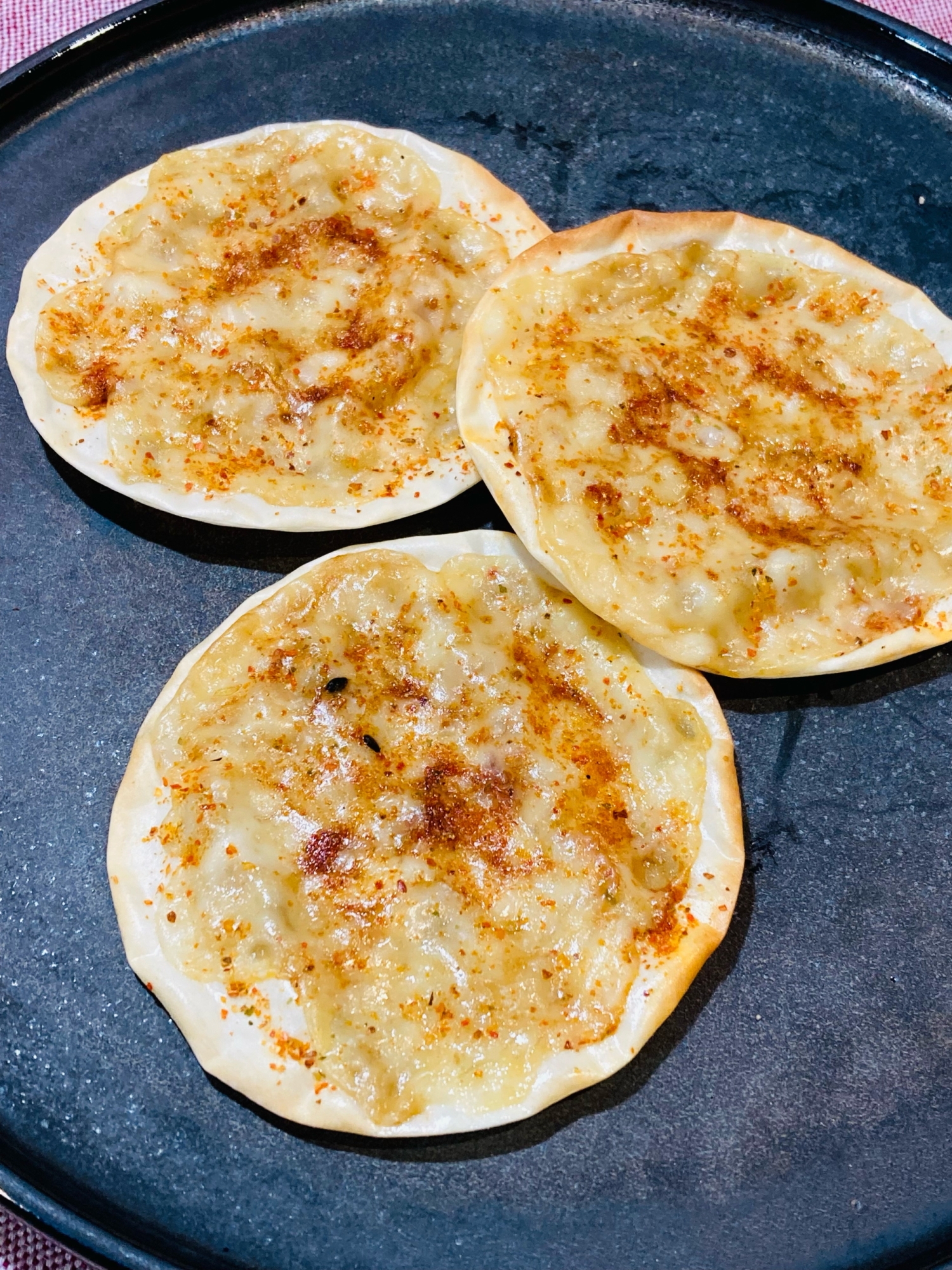 青い皿に盛り付けた餃子の皮の七味唐辛子せんべい