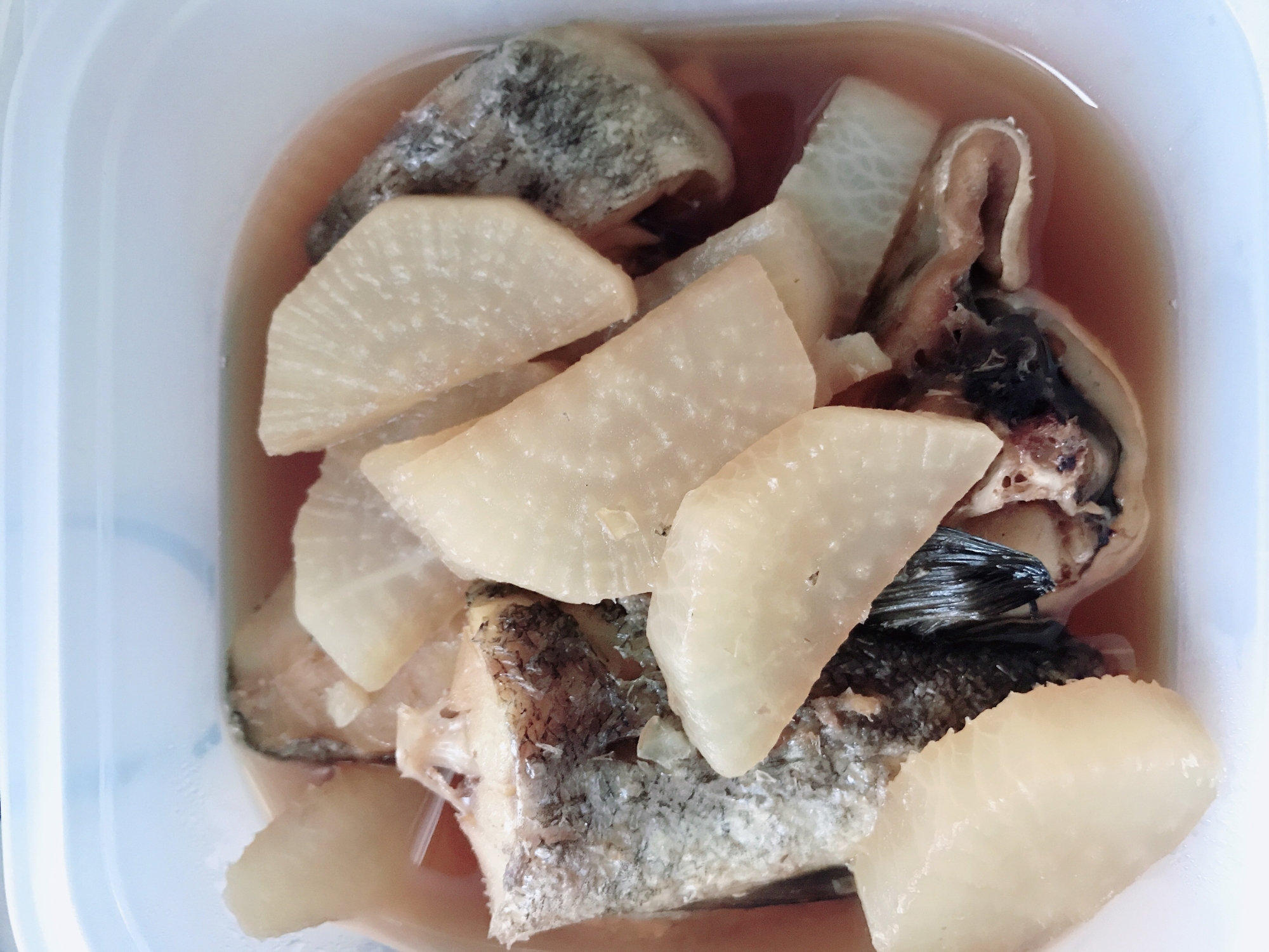 白い皿に盛りつけられた鱈と大根のしょうが煮込み