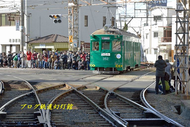居並ぶギャラリーの前を住吉公園駅へ進入するモ162号車