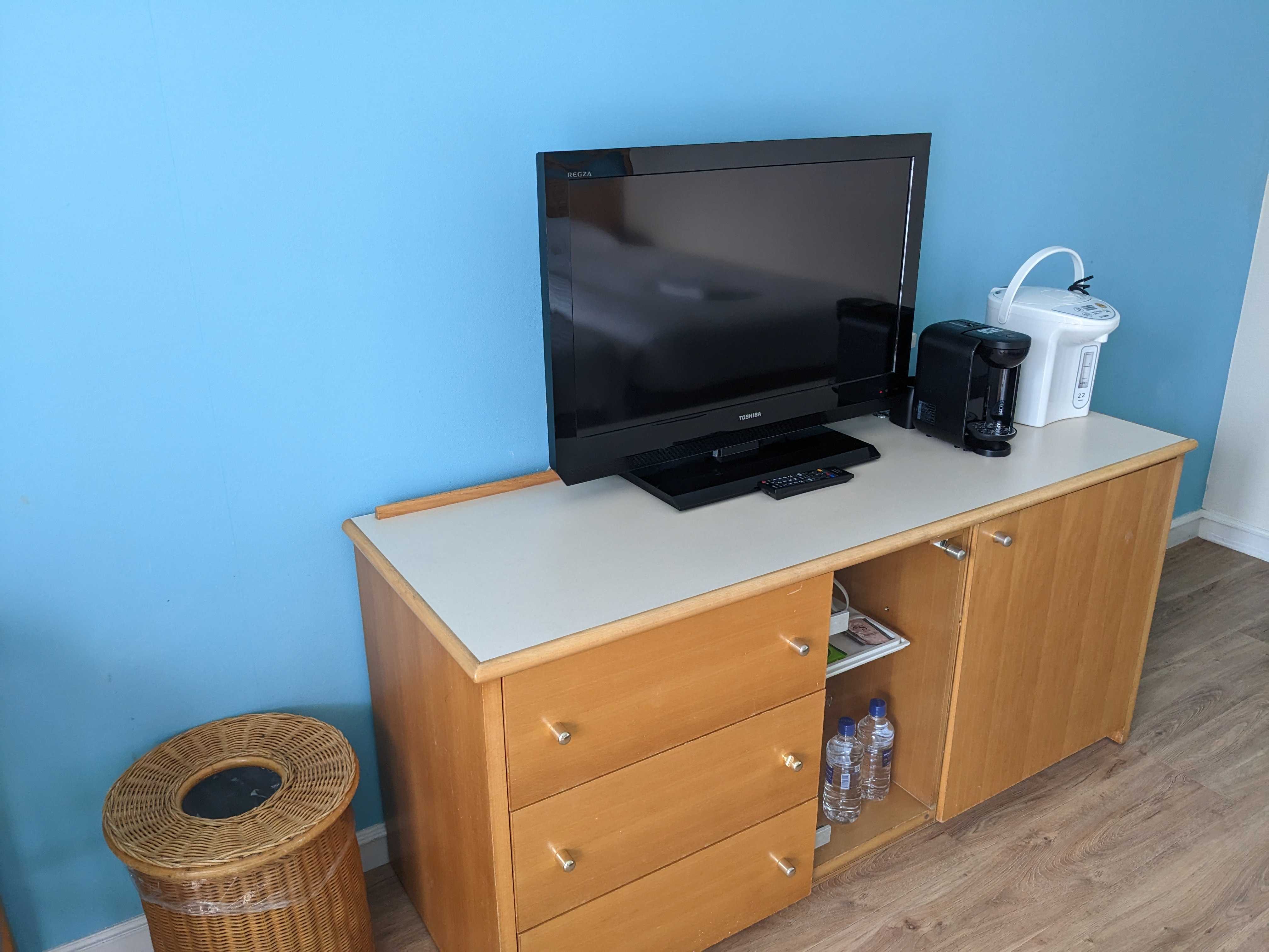 オクマプライベートビーチ＆リゾートのパームコテージの室内 テレビ、コーヒーメーカー、ポット