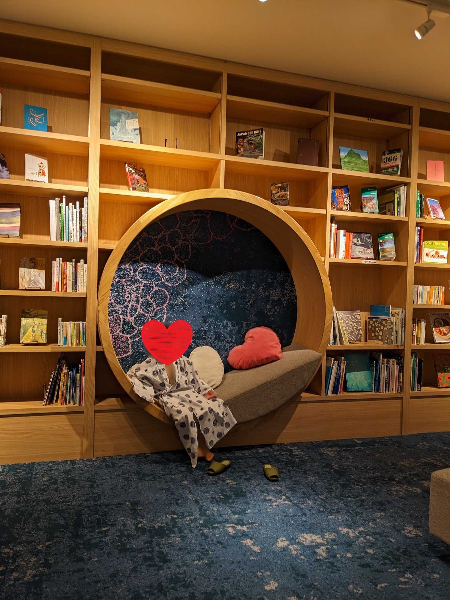 箱根ゆとわ　ライブラリーラウンジ　壁一面の本棚とオシャレな丸い椅子