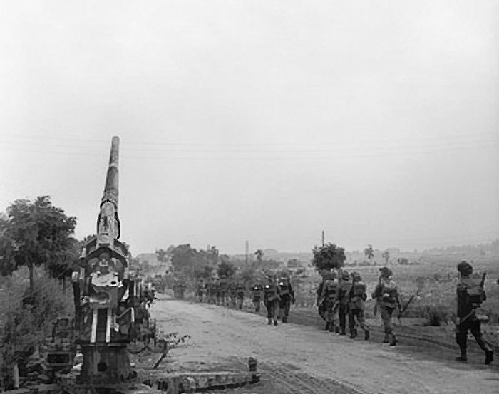 Infantry_moving_up_past_a_knocked-out_German_88mm_gun.jpg