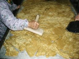 出来立ての熱くねっとりした黒糖汁を、ばあちゃんたちが手早く平にしていく