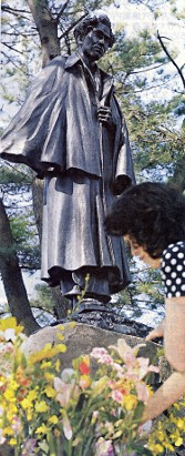 マント姿で等身大の生誕１００年記念銅像（朝日新聞から）