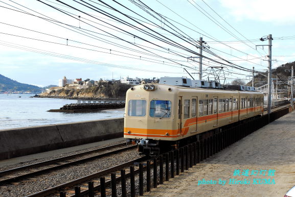 伊予灘沿いを走る伊予鉄道高浜線の電車