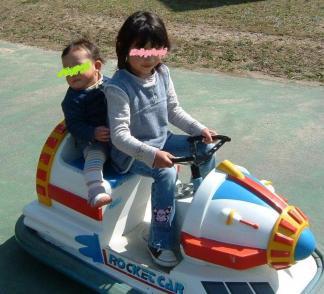 長女と三女：電動車に二人乗り(河畔公園)