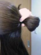 束ねた髪の根元付近を２つ折りにし、手で固定