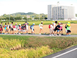 田んぼの道を通る子供たち