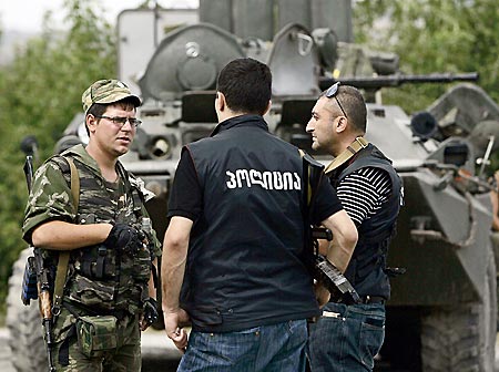 ゴリ郊外でロシア軍兵士（左）と話すグルジアの警察隊＝14日〔ＡＰ〕