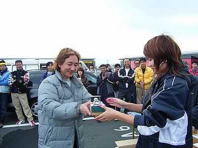 おねいさんから４位のトロフィをもらう相談役