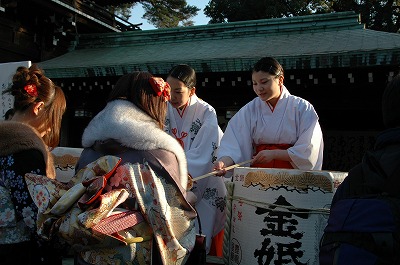 巫女さんから、御神酒を有り難く受けています