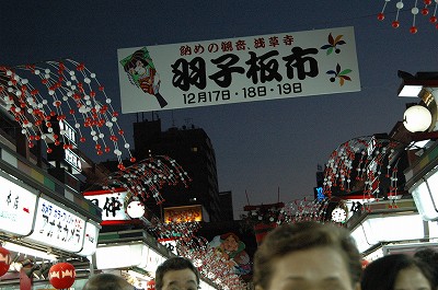 夕闇の中で羽子板市の垂れ幕が