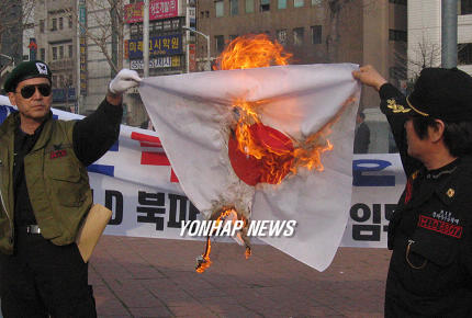 日本大使館前で日本国旗を燃やす朝鮮人。