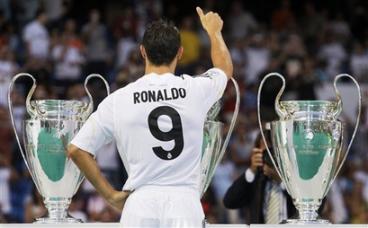 Cristiano Ronaldo from Portugal poses next to the clubs trophies during his presentation at the Santiago Bernabeu stadium.jpg