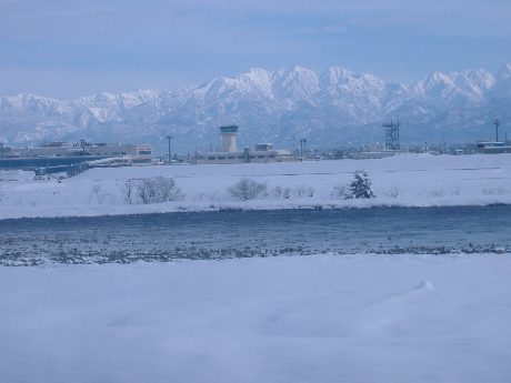 雪の立山連峰と神通川