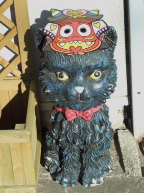 節分用のお面を被せた玄関脇の猫