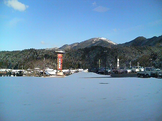 積雪が残る山里の集落近くにある
