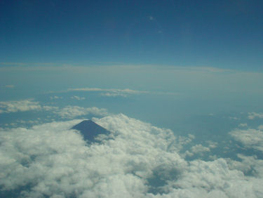 白い雲から顔を出す黒い富士山