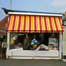 カラフルな売店。ビーサン、浮き輪…ちょっと砂にまみれてた。